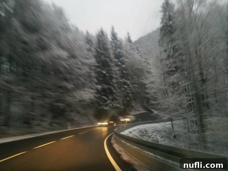 Cars traveling on a snowy highway, indicating winter driving conditions.