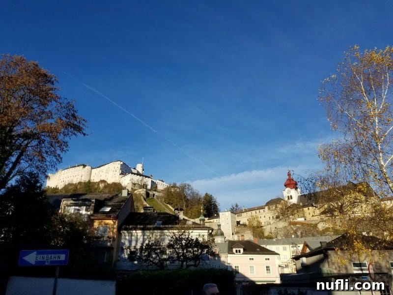 Salzburg castle and a historic convent perched majestically atop a verdant hill, dominating the city skyline.