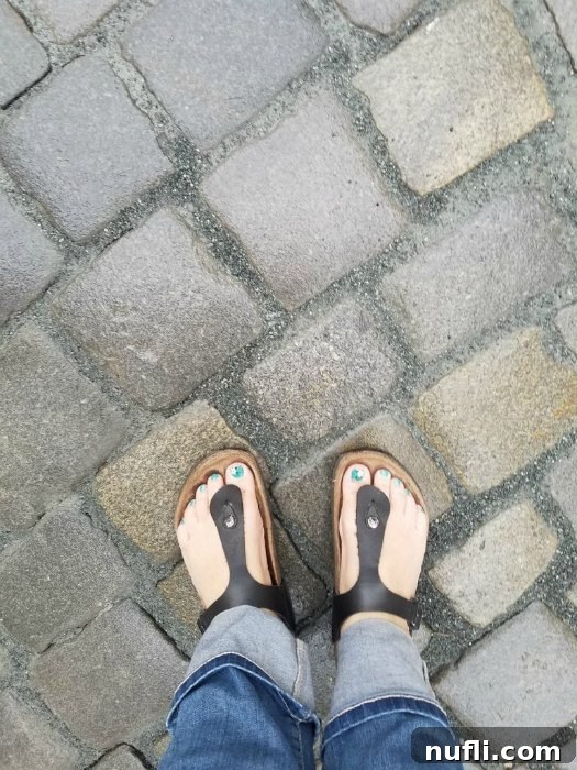 Birkenstock sandals resting on a brick path, highlighting a traveler's choice of footwear.