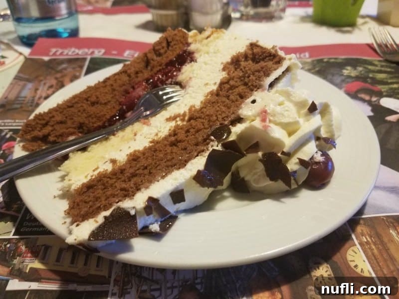 Germany: Where I Found What My Life Was Missing 6 Slice of authentic Black Forest Cake on a white plate, showcasing layers of cream, chocolate, and cherries