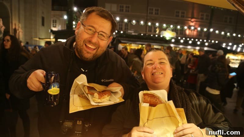 The Magic of Salzburg's Yuletide 8 Tammilee and John, smiling broadly, holding their delicious pretzels at the market