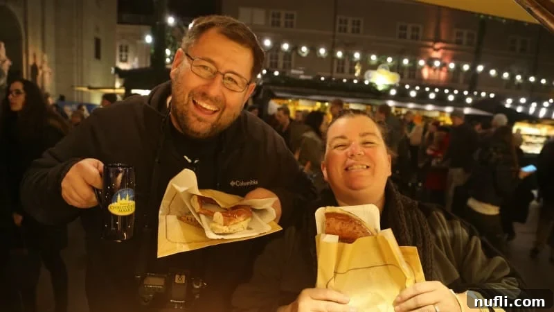 Tammilee and John smiling broadly while holding large pretzels at the market