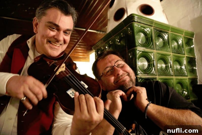 What Austria Taught Me I Needed 7 A candid moment featuring a violin player and John, capturing a lively interaction at an Austrian dinner