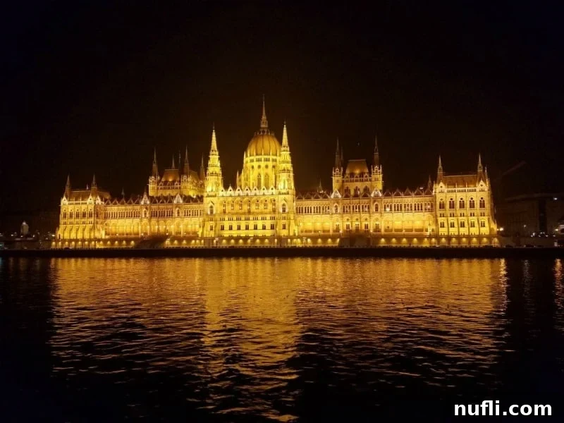 The stunning Budapest Parliament building illuminated at night, viewed from the Danube River
