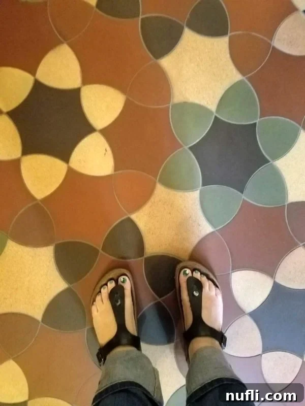 Tammilee's feet in Birkenstocks on a decorative tile floor in Budapest