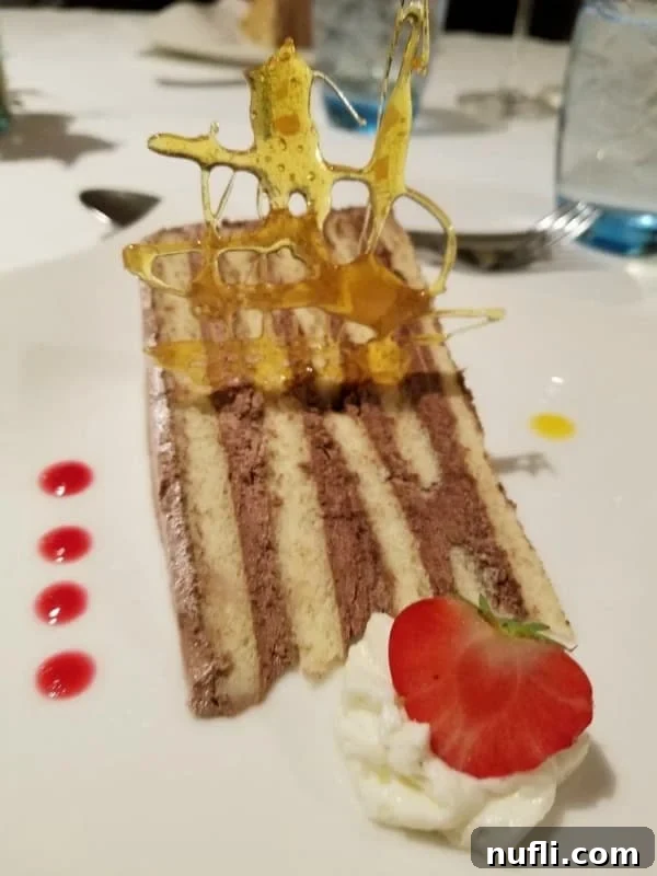 An elegantly decorated cake with sugar work and a fresh strawberry, a sweet treat