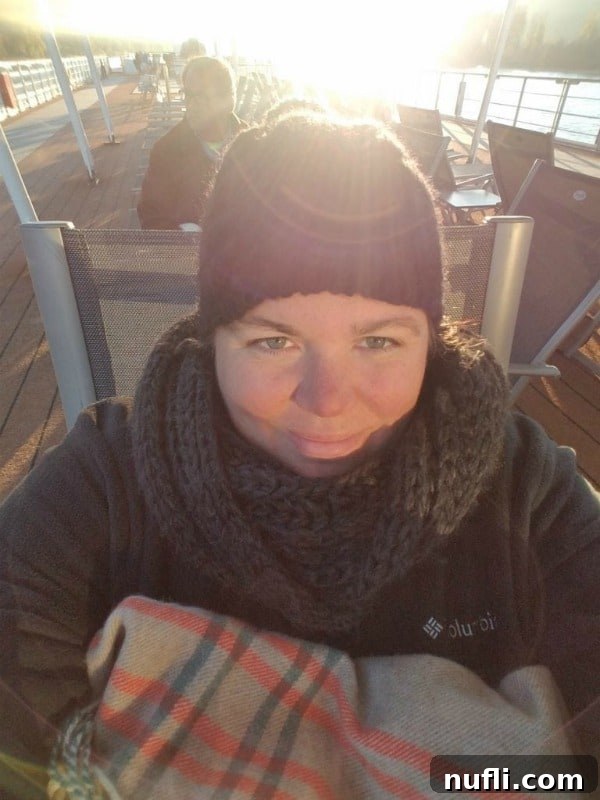 Tammilee wearing a hat and scarf on the deck of the Viking Vili 