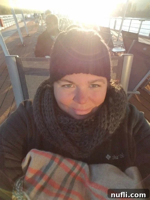 Tammilee bundled up in winter gear on the deck of Viking Vili, enjoying the scenic cruise