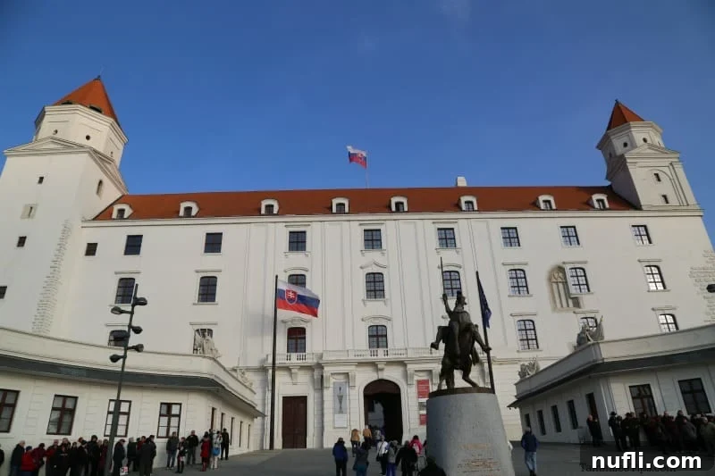 Bratislava Unveiled A Viking River Cruise Walking Experience 4 Bratislava Castle with a decorative figurine and the Slovak flag proudly flying against a blue sky.