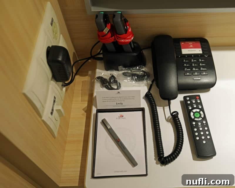 The Viking Vili River Cruise Ship: An Inside Look 6 Phone, remote, notepad, pen, and tour devices on a desk charging