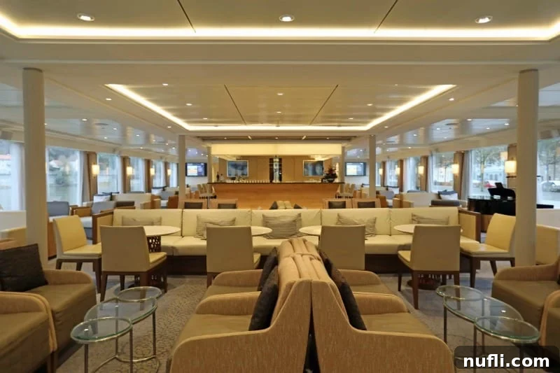 Discover the Viking Vili River Cruise Ship 10 Observation Lounge on the Viking Vili with lounge chairs and couches in a white bright room