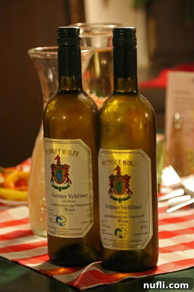 A close-up of a bottle of Gruner Veltliner wine prominently displayed on a table at a Heurigen, symbolizing Vienna's renowned white wine tradition.