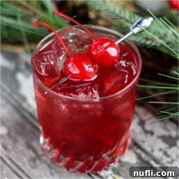 Festive Mulled Cherry Cider Cocktail 5 Mulled Cherry Cider cocktail in a short glass, garnished with a maraschino cherry for a festive look.