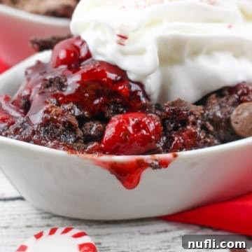 Chocolate Peppermint Cherry Dump Cake in a white bowl with whipped cream and peppermint candies