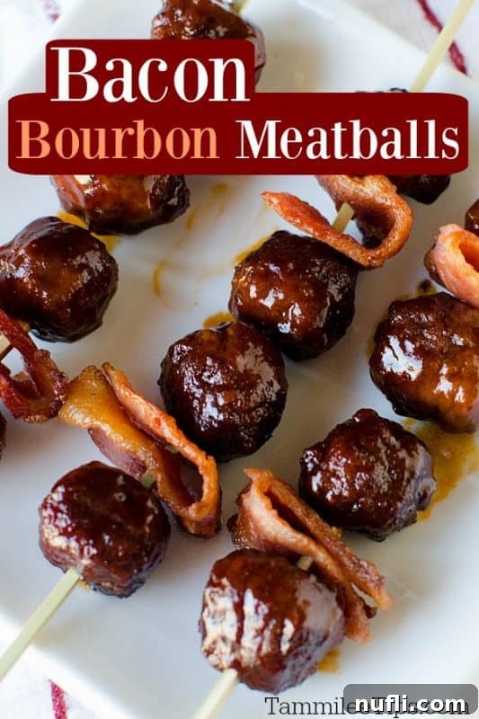 Bacon Bourbon Slow Cooker Meatballs 2 Close-up of golden brown Bacon Bourbon Meatballs skewered with crispy bacon, resting on a white platter, invitingly garnished.