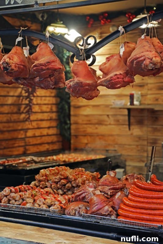 Pork, sausages, and more hanging on a rack over a barbecue