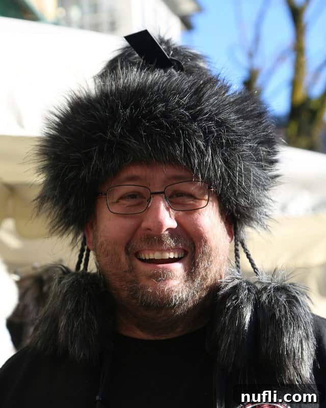 John wearing a stylish furry hat in Austria, enjoying the market atmosphere