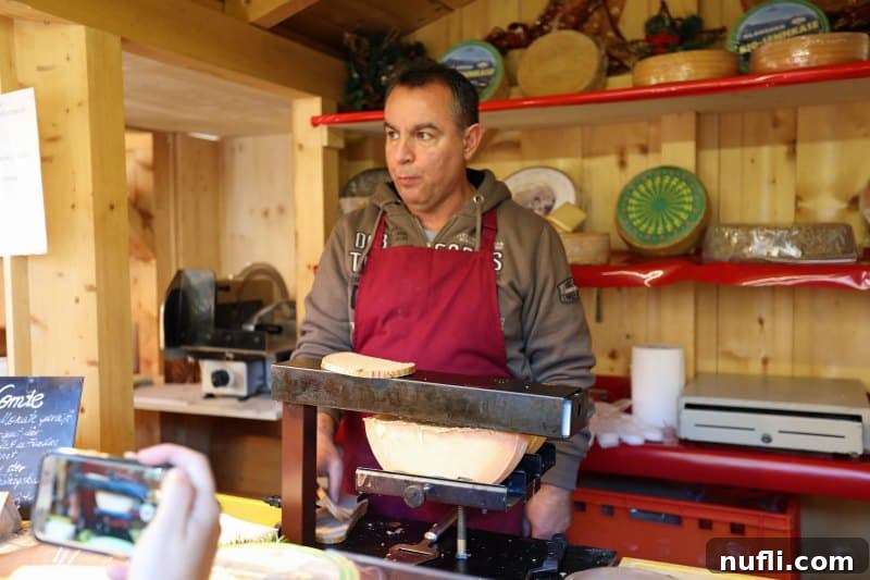 Man next to a large wheel of raclette cheese, preparing toasted cheese with bread