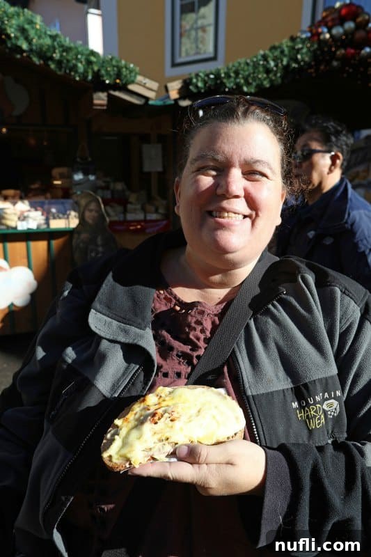 Tammilee holding raclette cheese bread with a joyful expression, savoring the delicious treat