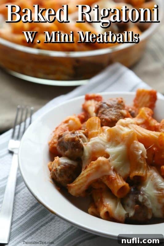 Hearty Baked Rigatoni with Mini Meatballs 2 A rustic bowl brimming with baked rigatoni and mini meatballs, garnished with fresh herbs, positioned next to a fork, inviting a delicious meal.