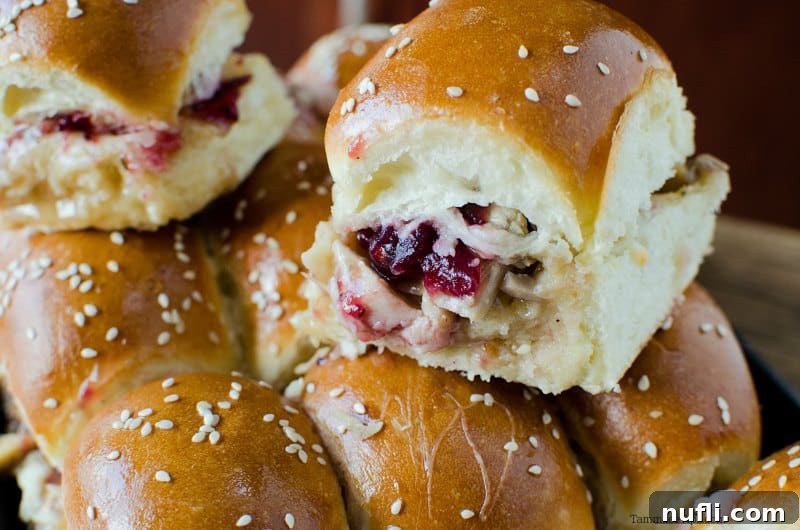 A festive stack of Cranberry and Leftover Turkey Sliders on a decorative serving platter, ready to be enjoyed.