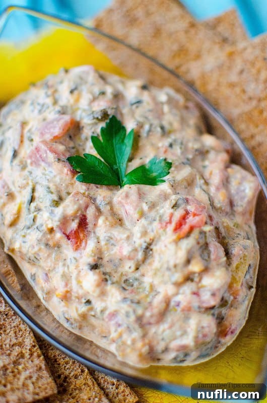 spinach dip in a glss bowl with crackers on either side 