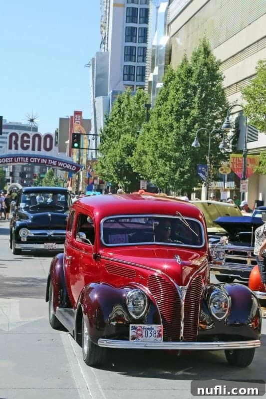 Hot August Nights Reno: The Classic Car Extravaganza 3 historic red car driving near the Reno Biggest Little City in the World Sign