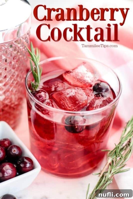 Elegant Cranberry Cocktail in a stemmed glass, garnished with fresh cranberries and a sprig of rosemary, set against a warm, festive background.