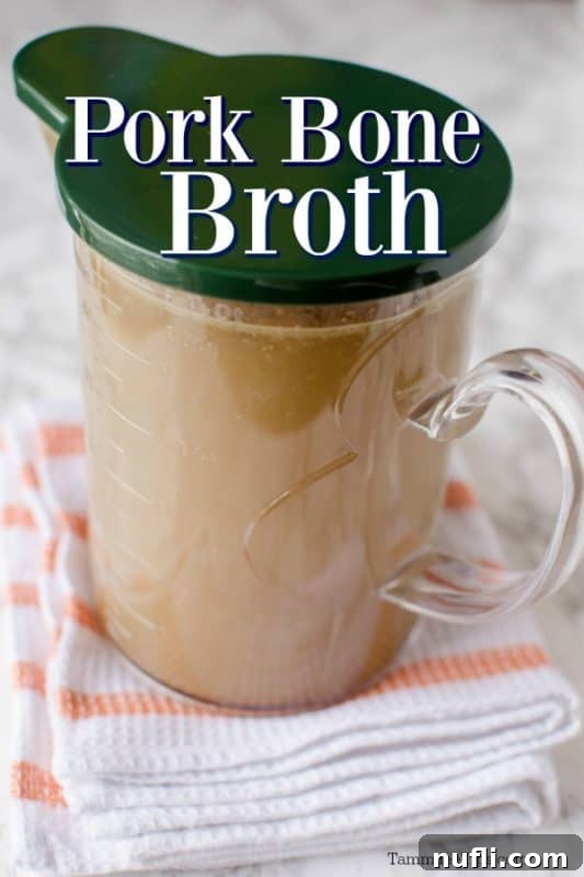 Rich, golden pork bone broth in a glass container with a lid, ready for storage.