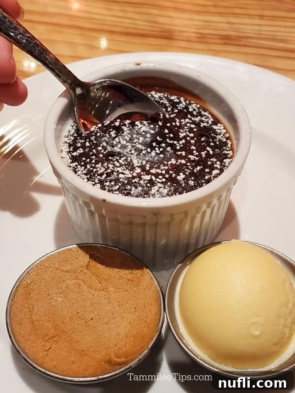 A spoon poised to delve into the rich, molten center of a chocolate cake, served in a white ramekin, with small side dishes of peanut butter and ice cream for garnish.