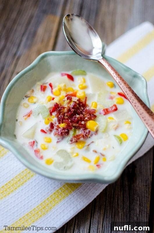 A close-up view of slow cooker corn chowder in a blue bowl, highlighting its rich, creamy texture and visible corn kernels.