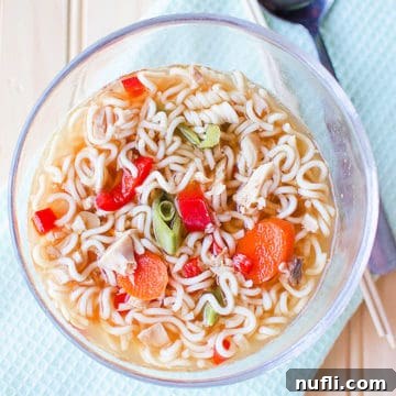 Chicken Ramen Soup in a glass bowl next to a spoon