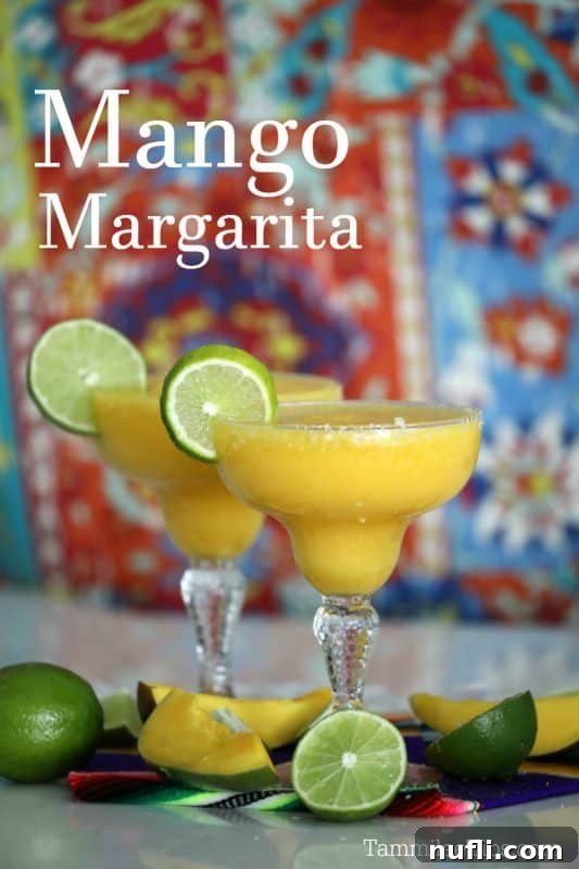mango margarita over two filled margarita glasses with lime wheels, tropical background, lime wheels and mango pieces at the base
