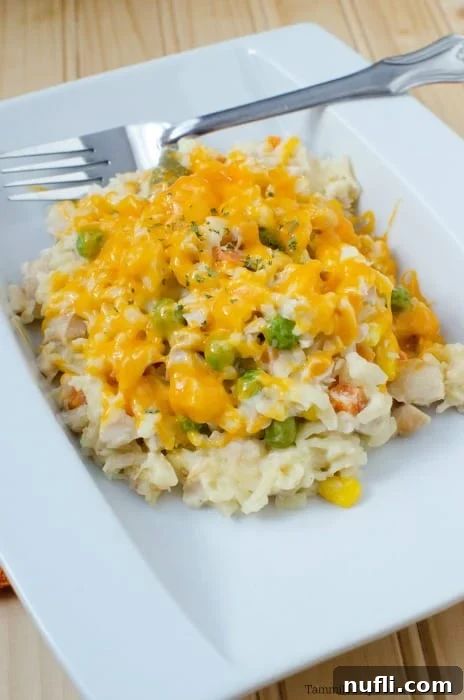 Chicken orzo casserole on a white plate with a fork