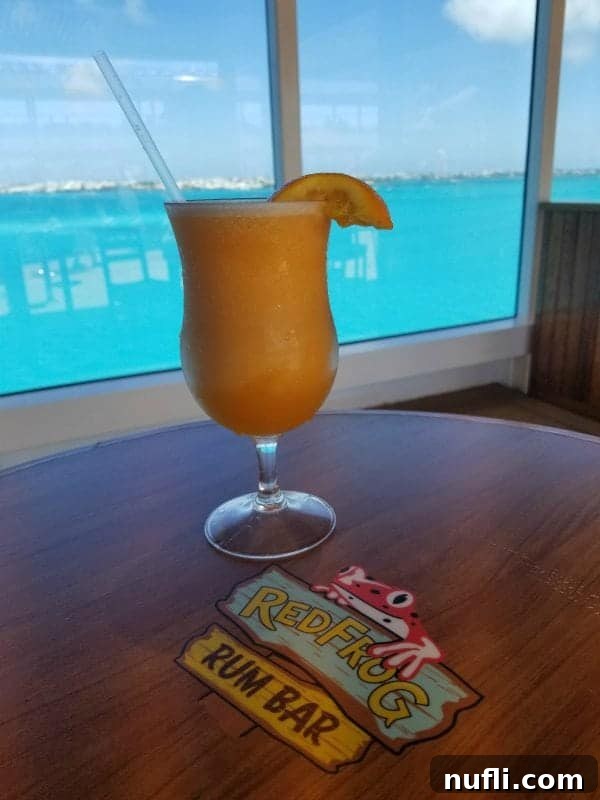Mango Magic Cocktail prominently featured on a table at the RedFrog Rum Bar on a Carnival cruise ship.