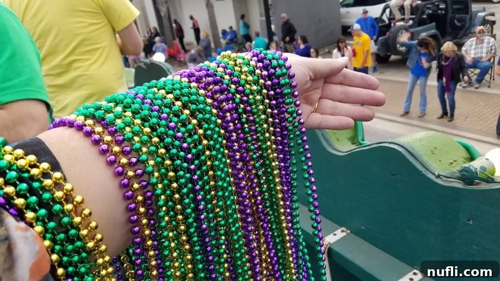 arm holding mardi gras beads