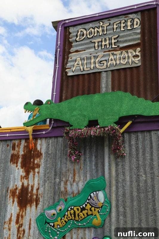 A playful 'Don't Feed the Gators' sign above a gator cut-out on a lively Mardi Gras float, adding a touch of local humor.