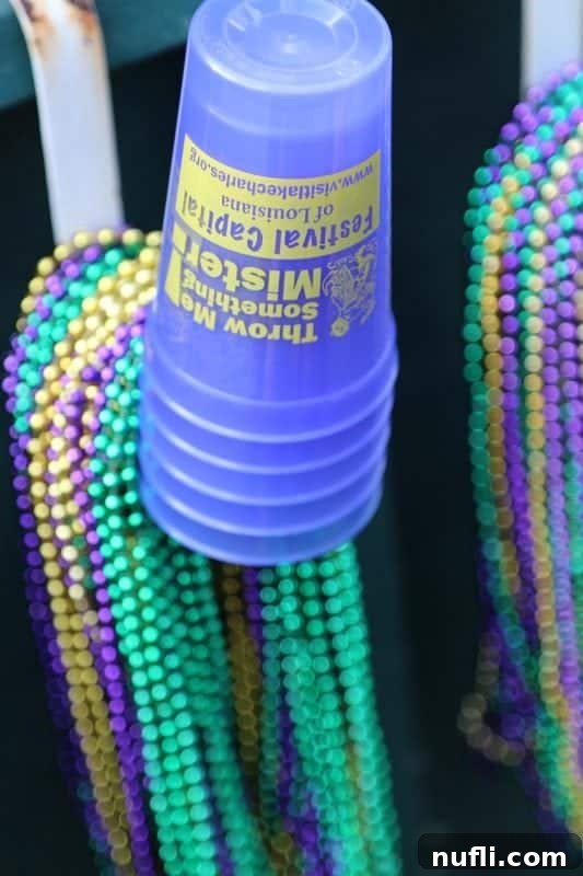 A collection of festive Lake Charles Mardi Gras cups and vibrant beads, cherished souvenirs from the celebration.
