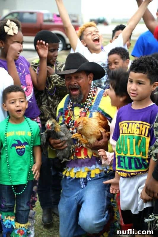 Rodney Victorian, the leader of the Chicken Run, holding two chickens and surrounded by a throng of eager children, moments after a chase.