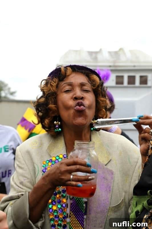A woman making a playful kissing face, holding up a jar filled with an assortment of colorful tequila-infused gummy worms.