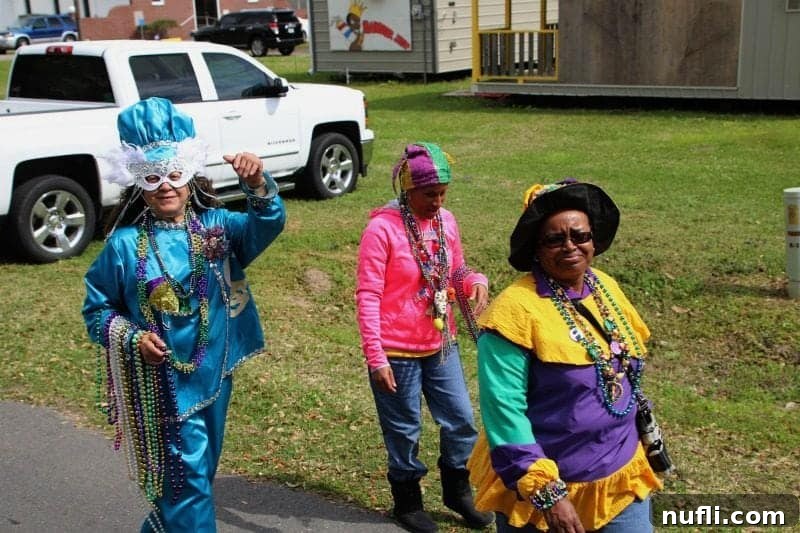 Three women dressed in festive Mardi Gras attire, their arms laden with an abundance of colorful beads, ready for the celebration.