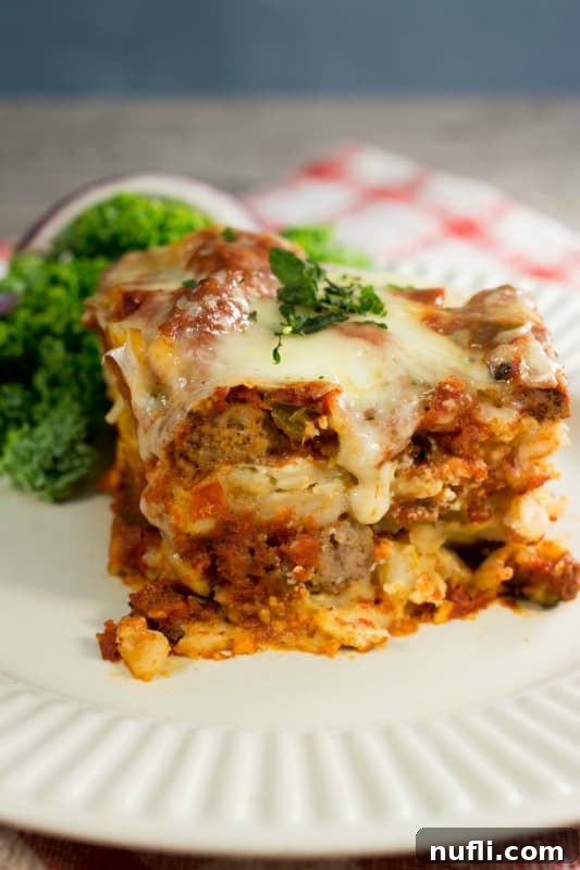 Another perfectly portioned square of Crockpot Lasagna on a white plate, ready to be enjoyed.