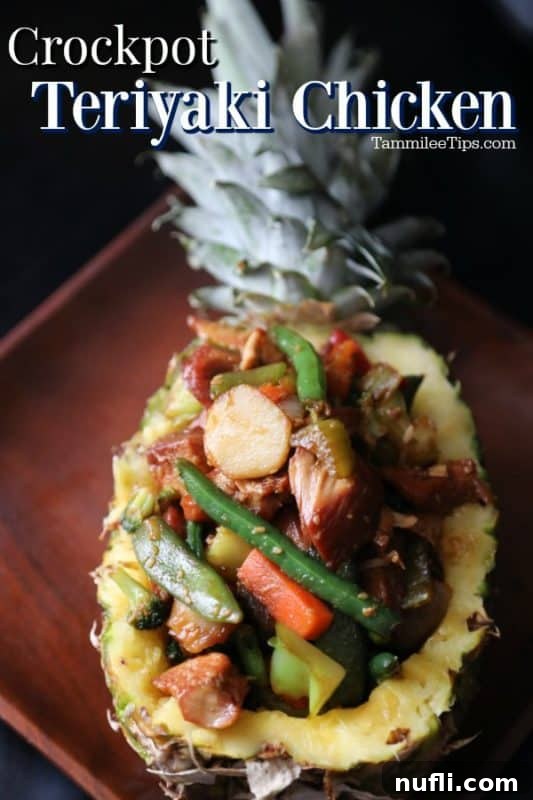 Crockpot Teriyaki Chicken over a pineapple filled with teriyaki chicken and vegetables on a wooden plate