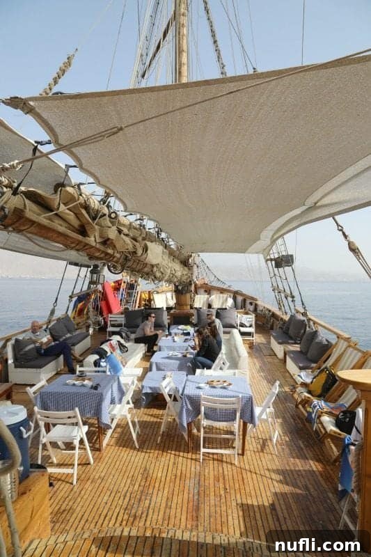 saiboat with tables and chairs around it in the red sea