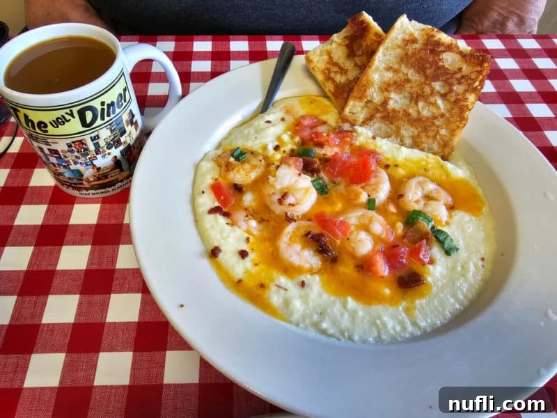 Orange Beach and Gulf Shores Must Try Restaurants 23 Shrimp and Grits next to an ugly diner mug on a checkered table cloth