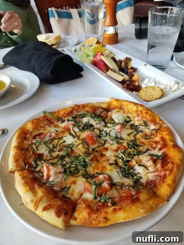 Orange Beach and Gulf Shores Must Try Restaurants 46 Margherita pizza and charcuterie plate on a white linen table
