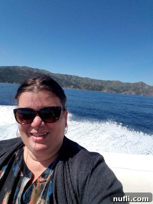 A traveler, Tammilee, on a boat with water splashing around, enjoying the dolphin excursion
