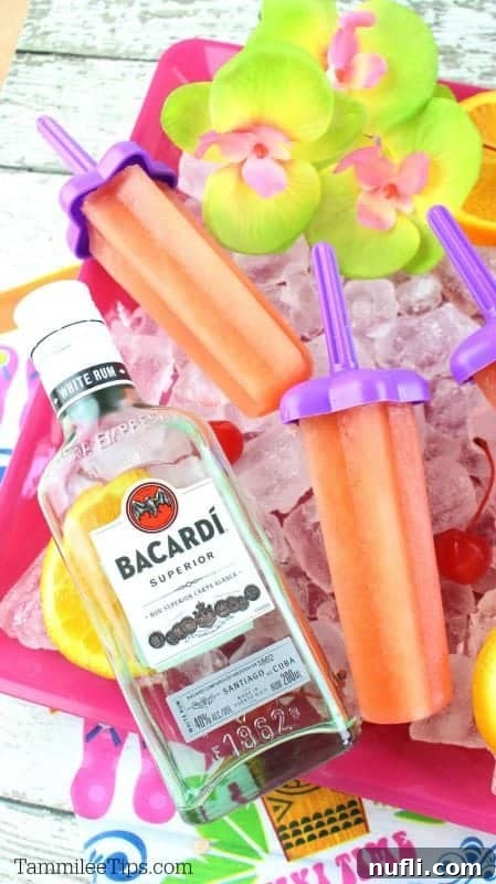 Bahama mama popsicles on a bed of ice with orange slices and cherries and a bottle of bacardi 
