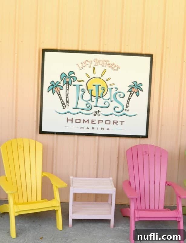 The charming sign of LuLu's Homeport Marina, with two inviting Adirondack chairs positioned to overlook the serene water, symbolizing relaxation and welcome.