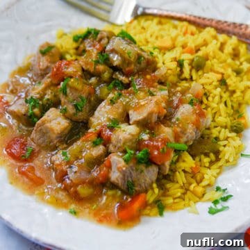 Tender Slow Cooker Pork Chili Verde 5 a white plate with Crockpot Pork Chili Verde and rice near a fork